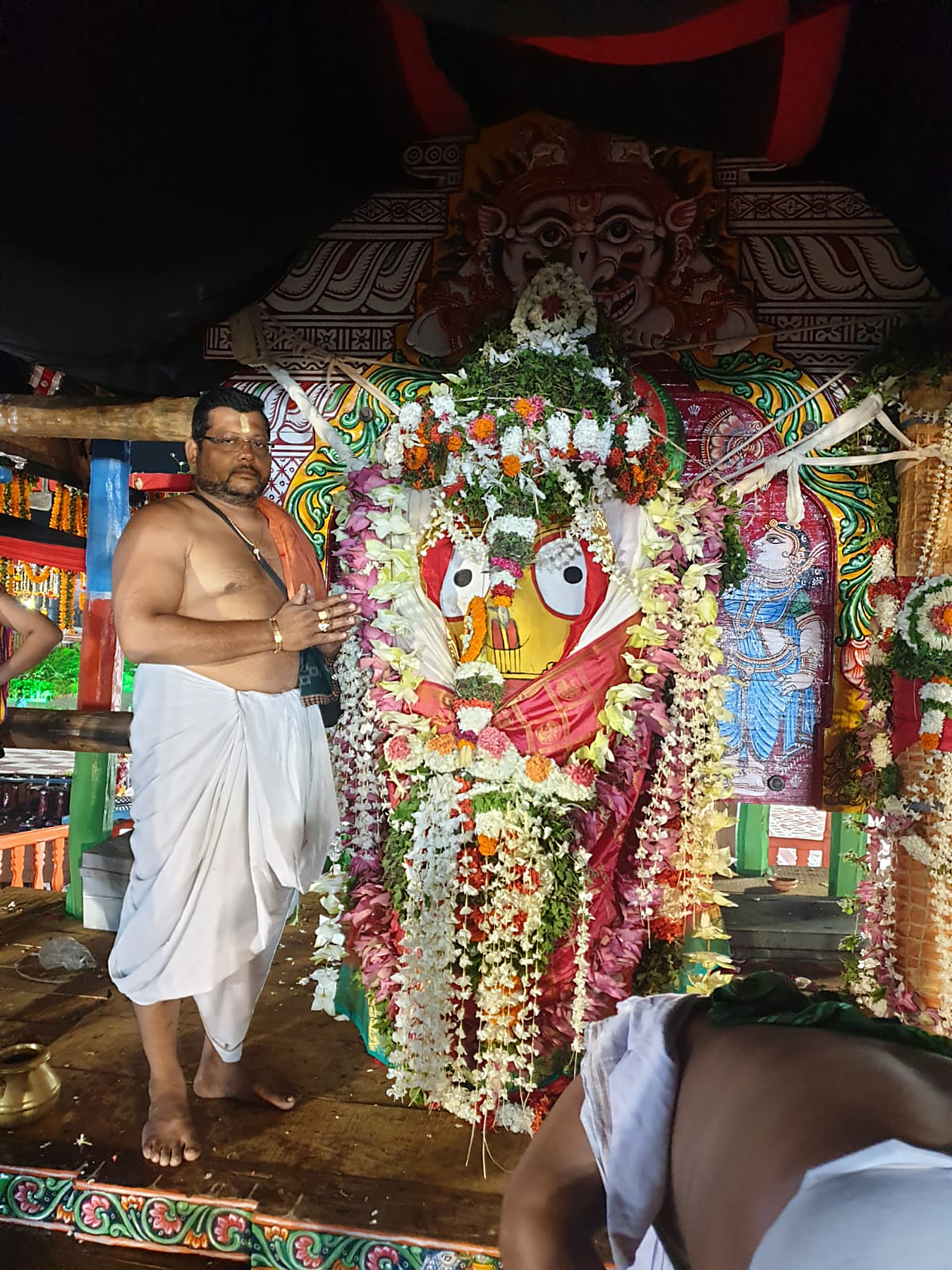 A Daita servitor standing in attendance beside the Lord during the seva on the chariot